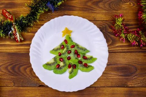 Christmas tree made of kiwi slices and pomegranate and Christmas decor Stock Photos