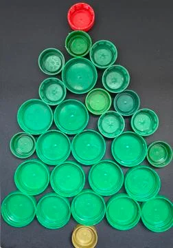 Christmas tree made of plastic covers on a black background, art craft. Stock Photos