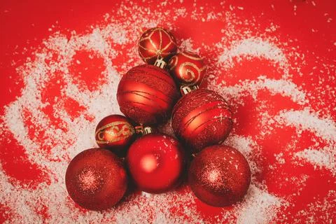 Christmas tree made from red balls with snow on a red background Stock Photos