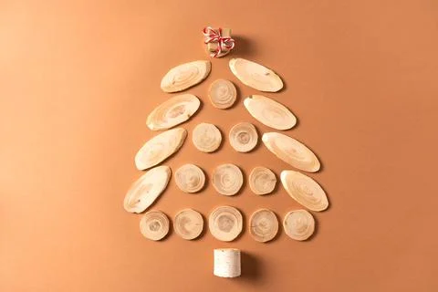 Christmas tree made of tree cuts with a small gift on top. Stock Photos