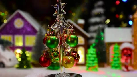 A Christmas tree moves against the backdrop of a large Christmas town Stock Footage 294682891