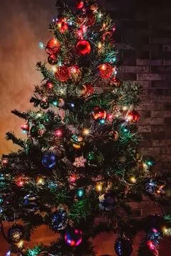 Christmas tree with multi-colored shining garland. Stock Photos