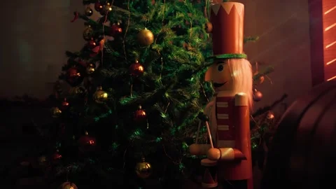 Christmas Tree with Nutcracker Ornament Standing in a Dimly Lit Living Room 库存影片 331106848