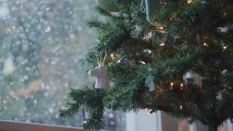 Christmas Tree with Ornaments in Front of Window with Snow Falling Outside Stock Footage 208756186