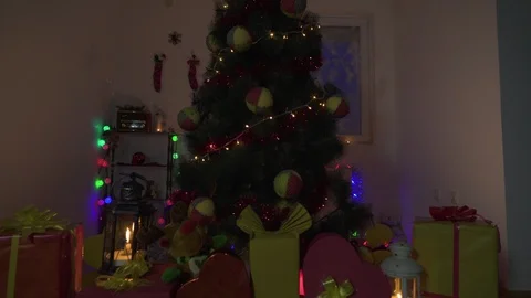 Christmas tree with ornaments, tilt down to gift boxes and lanterns, crane shot. Stock Footage 100054945