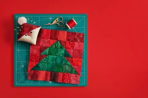 Christmas tree patchwork block, pincushion like Santa, scissors, spool of t.. Stock-Fotos