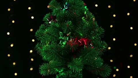 Christmas tree with patterned rays of light rotates on a black background Stock Footage 246852825