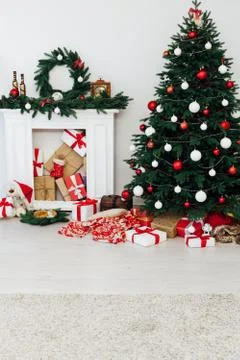 Christmas tree pine with fireplace interior of the house new year decor gifts Stock Photos