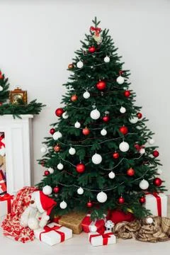 Christmas tree pine with fireplace interior of the house new year decor gifts Stock Photos