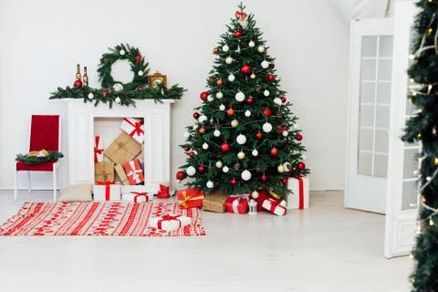 Christmas tree pine with fireplace interior of the house new year decor gifts Stock Photos
