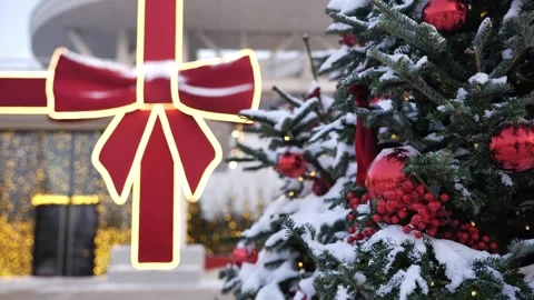 Christmas tree with red decorations and snow against blurred festive lights bow Stock Footage 335998618