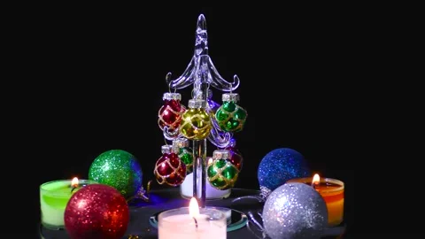 Christmas tree revolves surrounded by multi-colored candles and balls Stock Footage 162628090