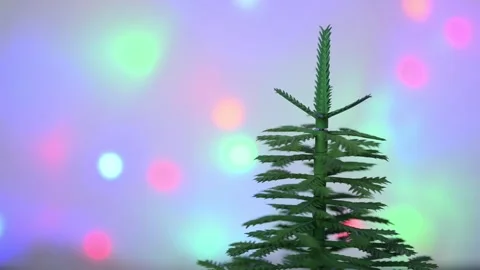 Christmas tree rotates against a background of blurred multicolored garlands. Stock Footage 284456624