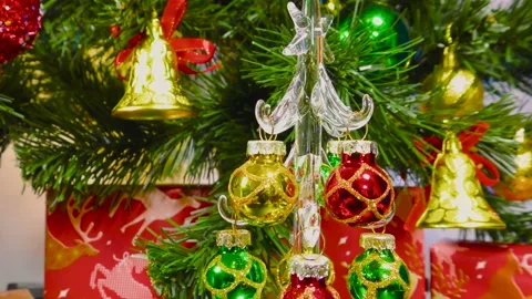 Christmas tree rotates on the background of a green Christmas tree and gifts Stock Footage 202185366
