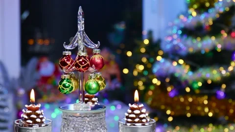 A Christmas tree rotates on a stand, surrounded by burning candles Stock Footage 260878775