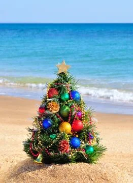 Christmas tree on sand in beach Stock Photos