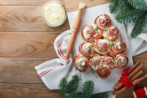 Christmas tree shape cinnamon rolls or cinnabon buns with cinnamon and cream  Stock Photos
