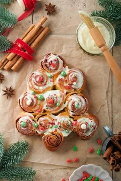 Christmas tree shape cinnamon rolls or cinnabon buns with cinnamon and cream  Stock Photos
