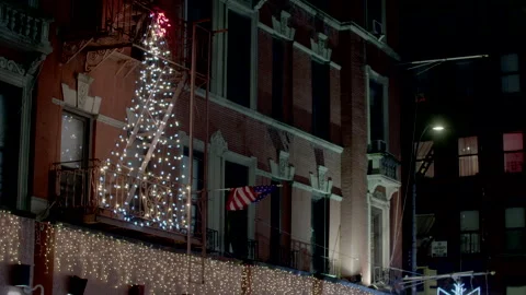 Christmas tree shape in lights hung from a fire escape in Little Italy. Stock Footage 257479509
