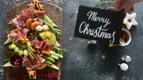 Christmas tree shaped cheese and charcuterie board with dark background.  Stock Footage 345634870