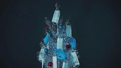 Christmas Tree shining lights and decorated with masks, gloves and balls Stock Footage 143532242