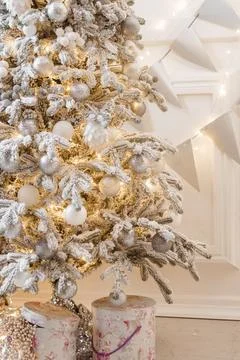 A Christmas tree sprinkled with artificial snow in the New Year's interior. Stock Photos