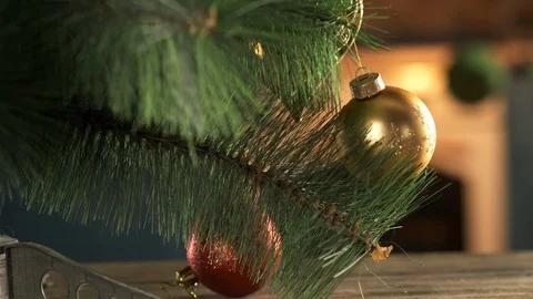 Christmas tree stand in spacious room with fireplace, several balls hang on tree Stock Footage 116795541