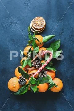 Christmas tree with tangerines, candy cane, spices and pine cones decorated with Stock Photos