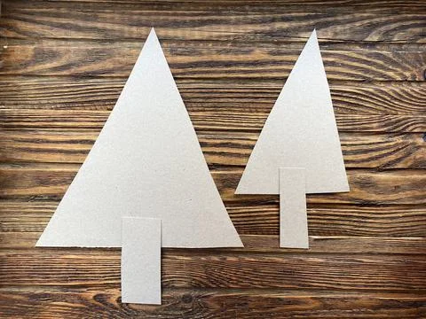 Christmas tree triangle shape made of cardboard on a wooden background. Stock Photos