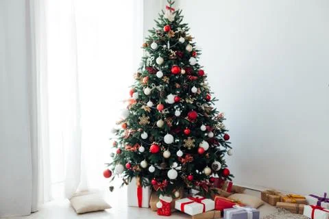 Christmas tree by the window with gift decor for the new year interior holiday Stock Photos