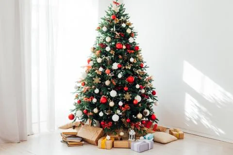 Christmas tree by the window interior of the room New Year holiday gifts Stock Photos