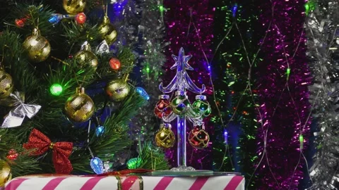 Christmas trees and a gift on the background of New Year's rain and gerlands Stock Footage 144841217