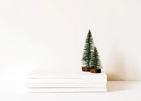 Christmas trees on a stack of magazines on white background Stock-Fotos