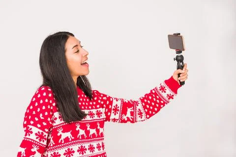 Christmas video call techbology using a cellphone for zoom. Latin woman on white Stock Photos