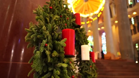 Christmas wreath of spruce branches, red berries and candles in the church. Stock Footage 133770089
