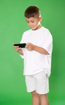 Chroma key compositing. Boy in white clothes scrolling through smartphone screen 스톡 사진