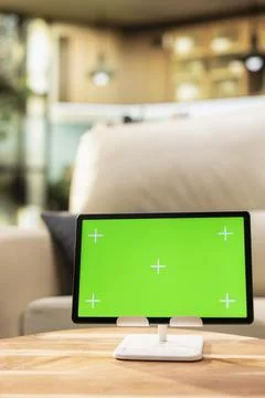 Chroma key display on tablet in bright spacious room with coffee table Stock Photos