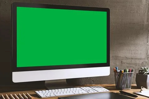 Chroma key green screen, angled view computer on table with creative tools .. Stock Photos