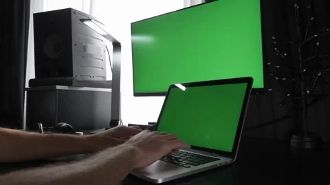 Chroma key green screen. Man is working on laptop computer with green screens Stock Footage 150700236