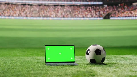 Chroma key isolated laptop screen placed at low angle on grass with soccer ball Video stock 337996426