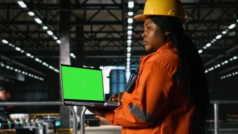 Chroma key on laptop screen with engineer in helmet examining metalwork Stock Photos