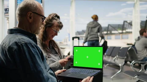 Chroma key on laptop screen used by senior people in airport lounge Stock Footage 343737447