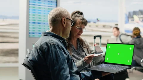 Chroma key on laptop screen used by senior people in airport lounge Stock Footage 343742315