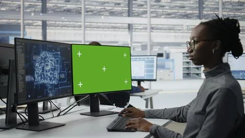 Chroma key PC used by microchip factory specialist reviewing production with AI Stock Photos