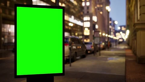 Chroma key poster board on a city sidewalk at dawn with passing traffic Stock Footage 345500883