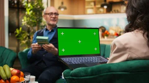 Chroma key screen on laptop with old woman and man relaxing in living room Stock Photos