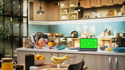 Chroma key screen laptop placed on empty wooden table in rustic kitchen space Stock Footage 327099778