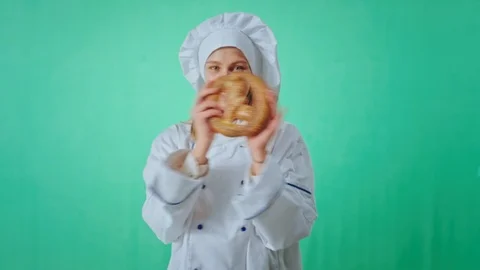 Chroma key studio attractive baker woman in the uniform take a fresh pretzel Stock Footage 125487164
