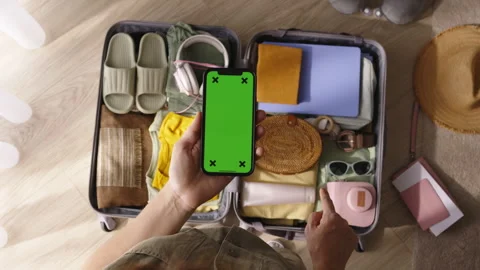 Chromakey phone, packed suitcase. Hand finger point to things in luggage Stock Footage 252196865