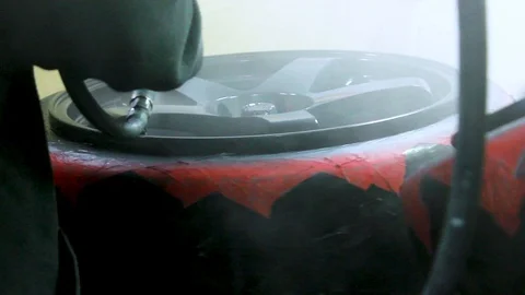 Chrome Black Alloy Wheels Being Spray Painted by a Mechanic at a Garage. Stock Footage 106672669